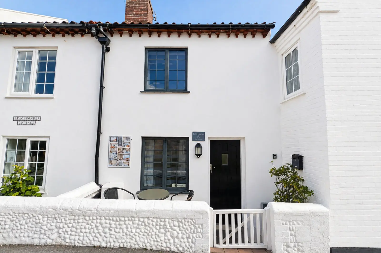 Exterior photograph of Sea Spray cottage - a white two story terrace building