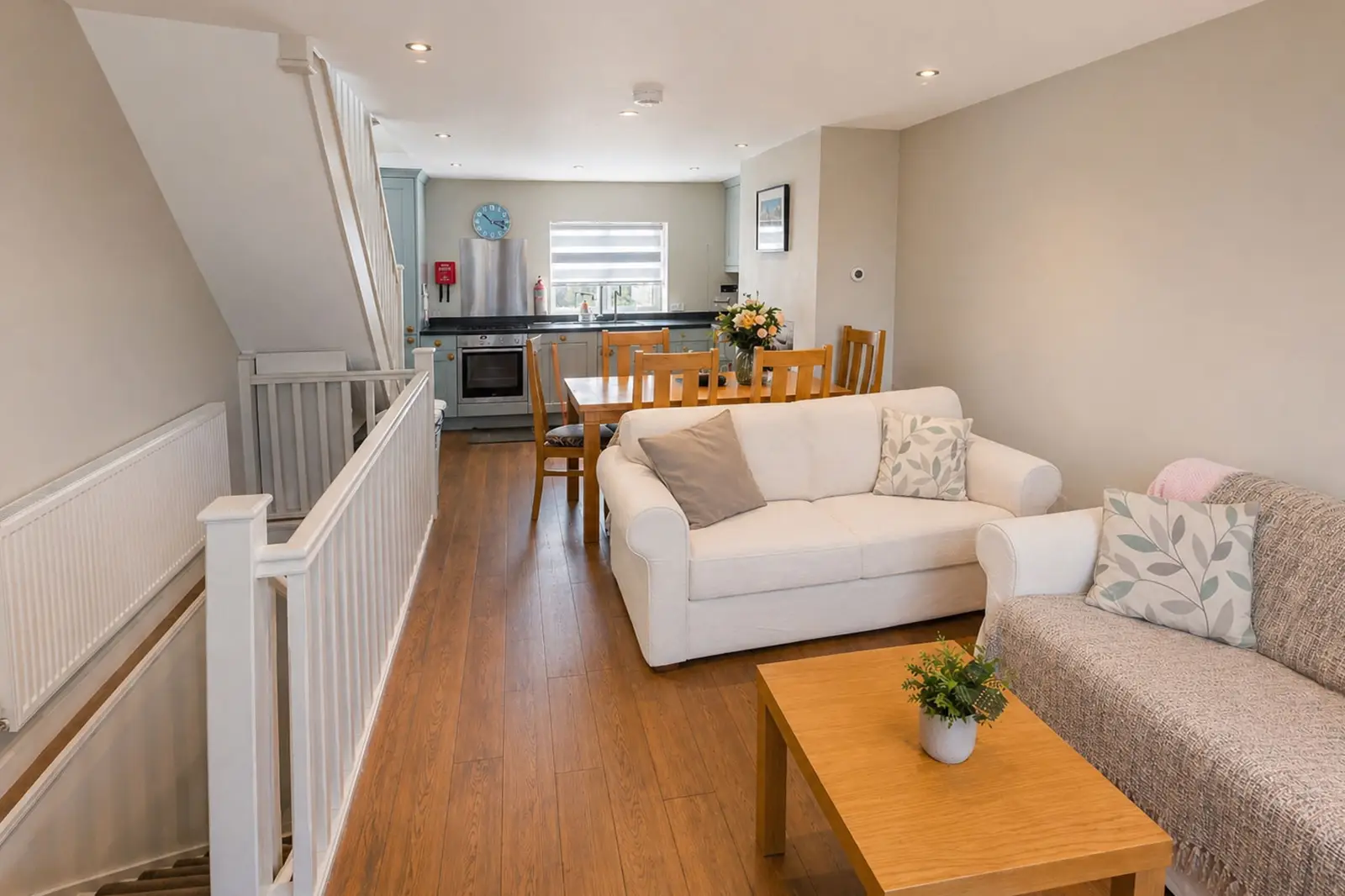 A second floor living room with a kitchen in the background