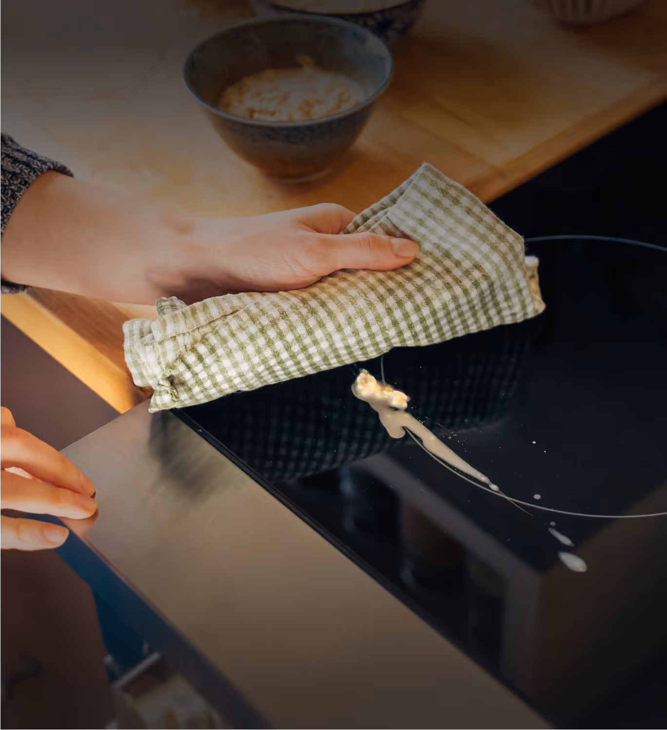 A mother wiping down to easy to clean glass stovetop