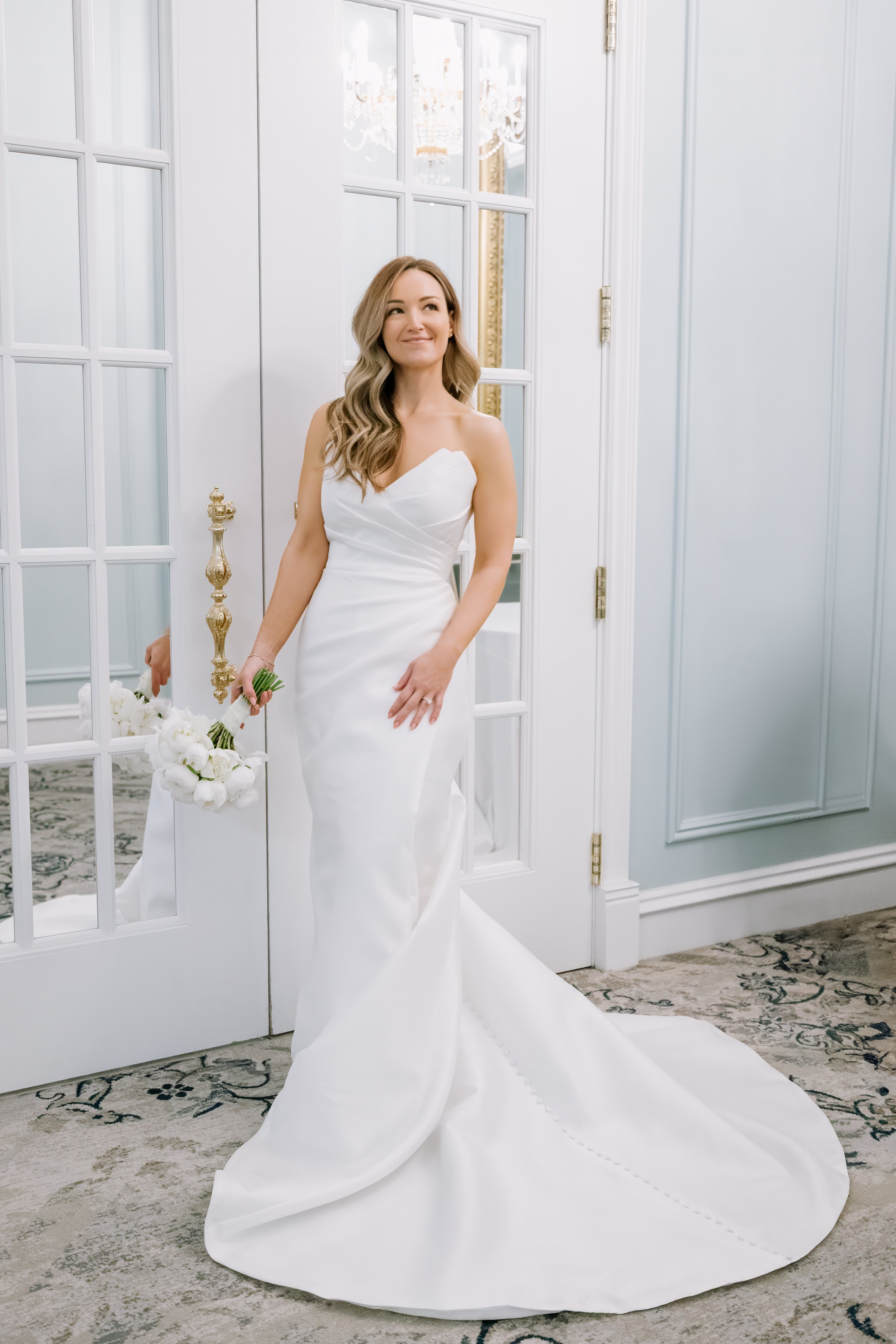 bride in front of doors holding bridal bouquet at carmichael hotel