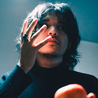 man holding apple fruit while raising his right hand