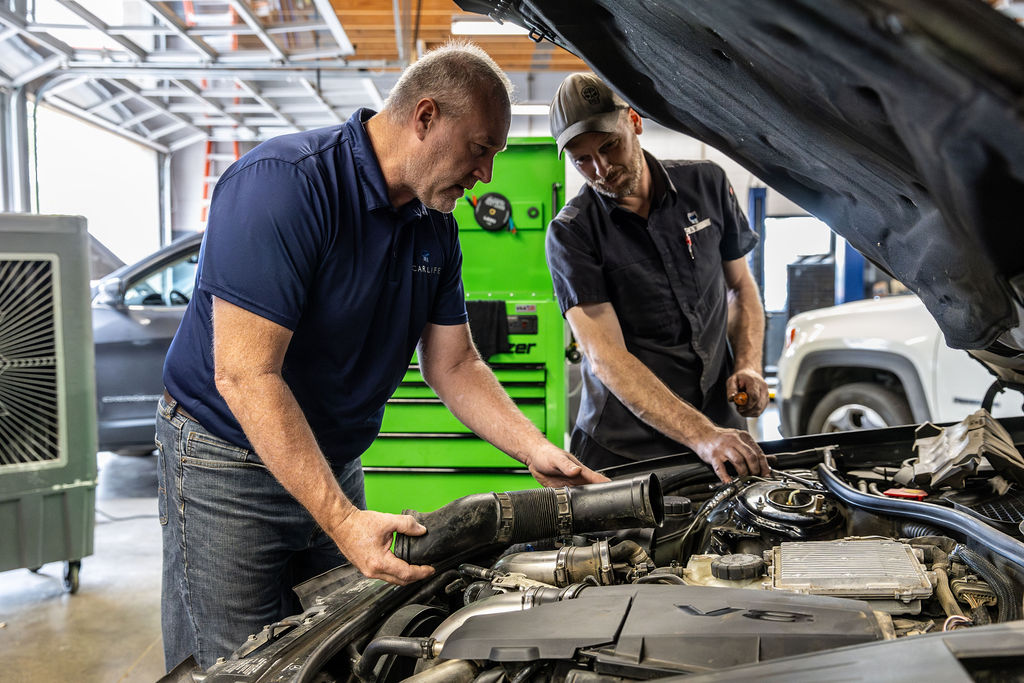 Multiple Car Life Technicians Servicing a Vehicle