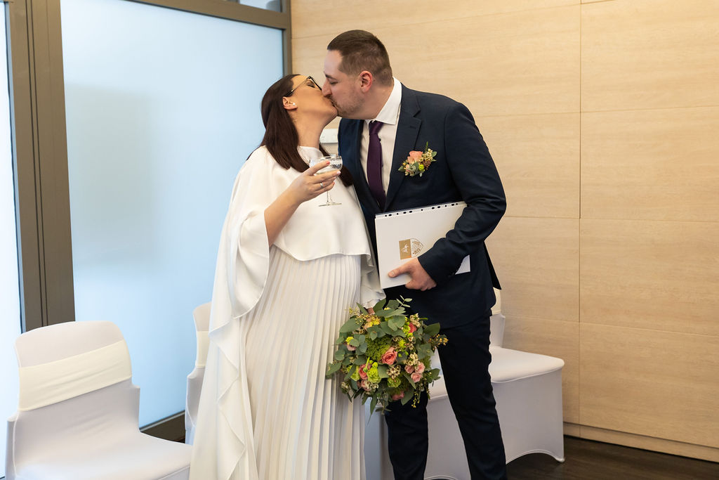 Kismama menyasszony és vőlegény első hitvesi csókja a gyáli polgári szertartáson – érzelmes pillanatkép egy kis esküvőről.