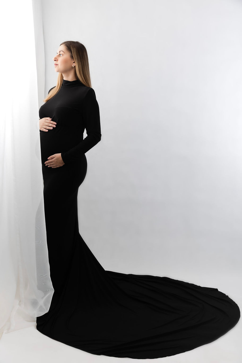 elegáns letisztult kismamam portré uszályos fekete ruhában fehér stúdióban Gyálon