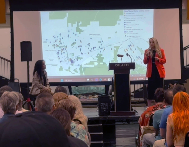 Presentation being given with people in the crowd watching with interest