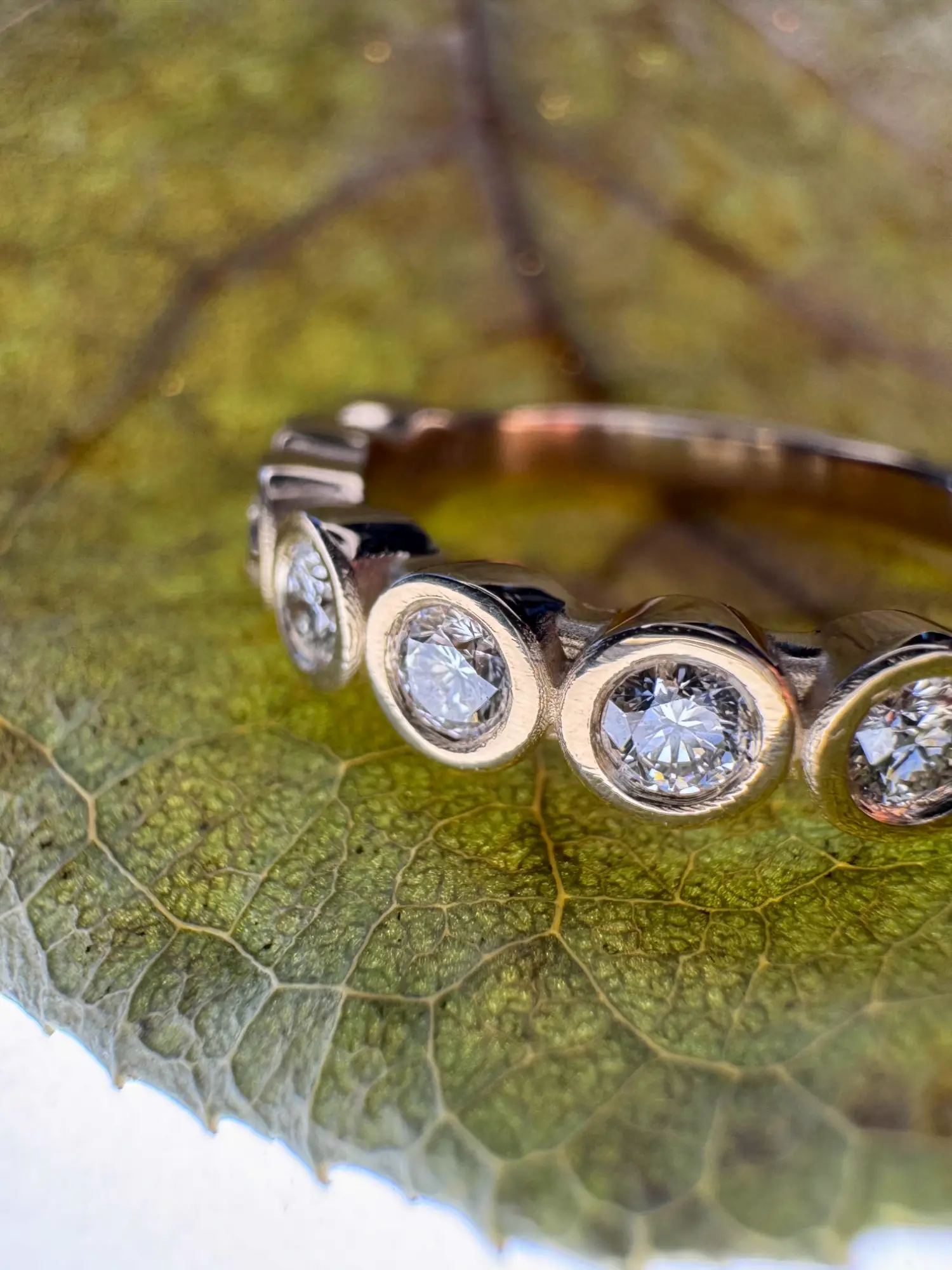 An elegant ring adorned with an orange stone, resting on a luxurious gold backdrop.