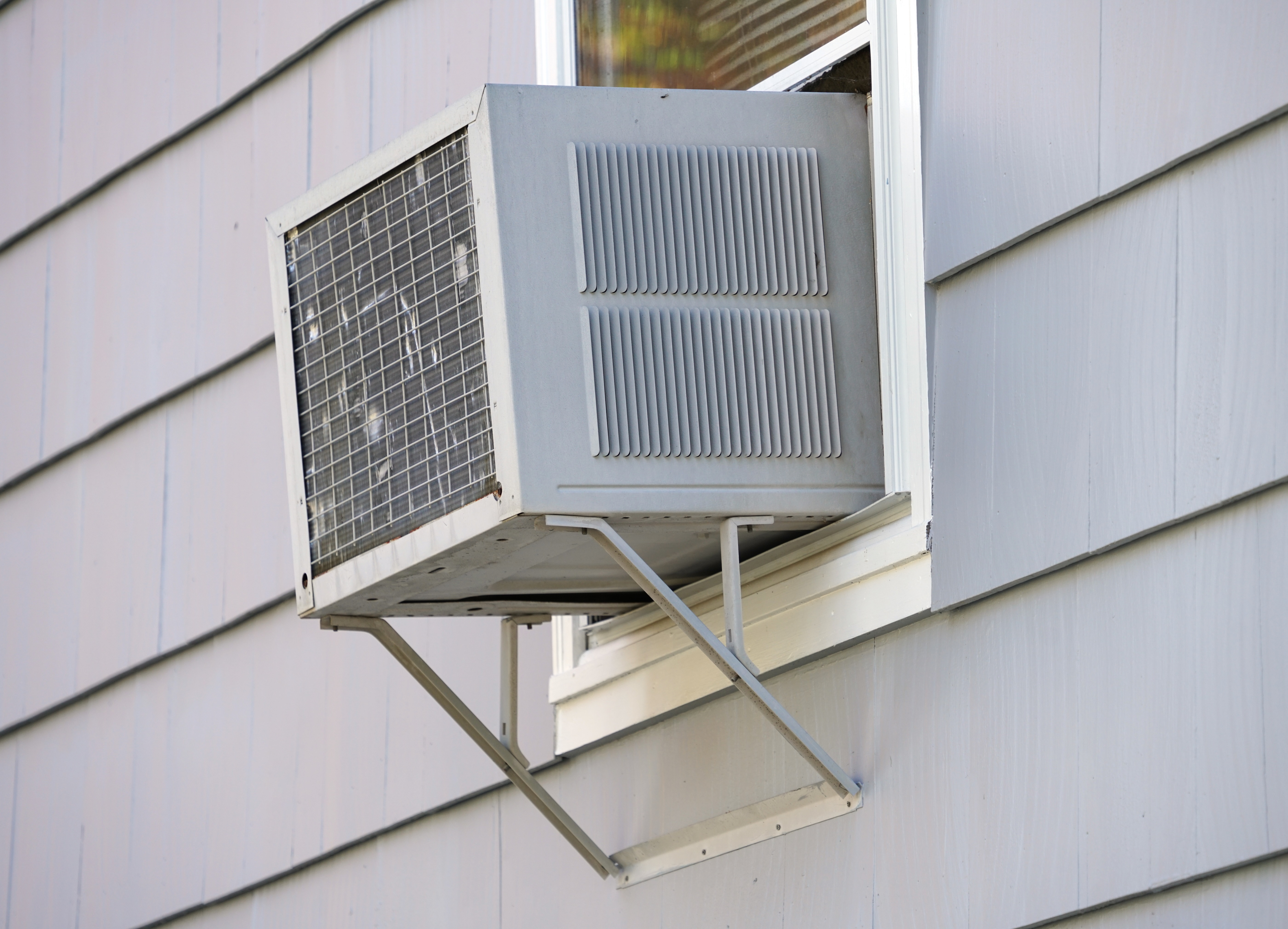 Window air conditioner unit installed on a white house