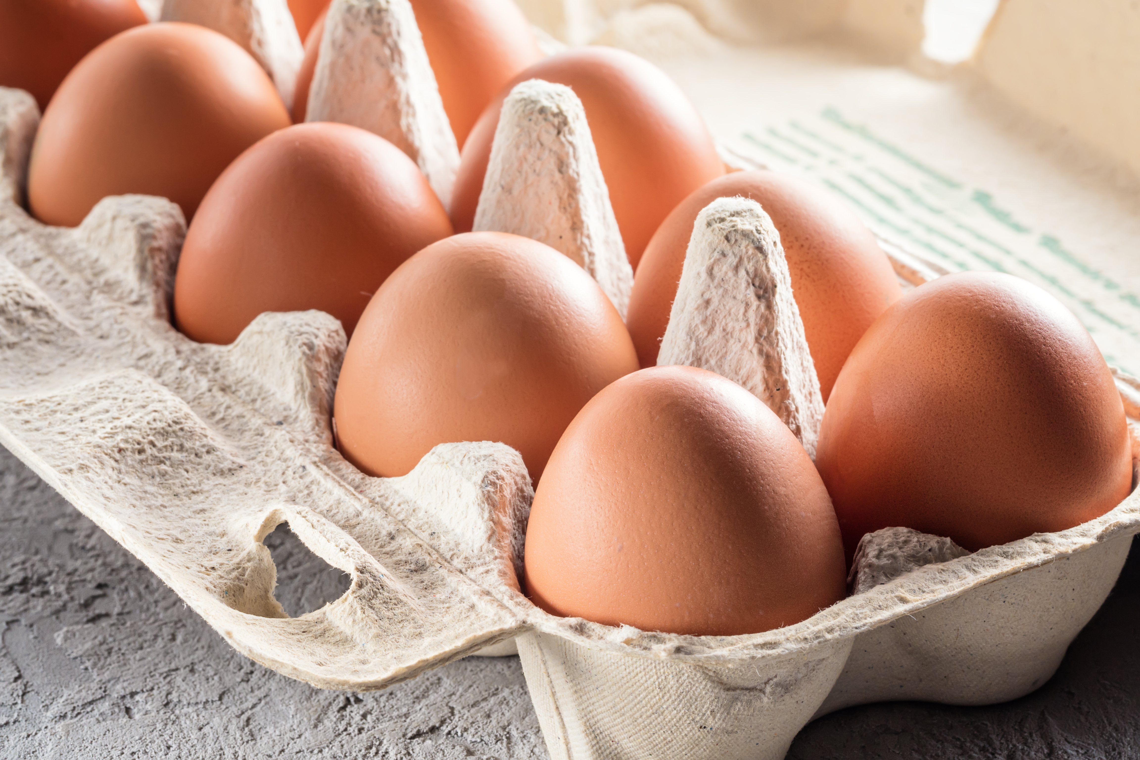 Brown farm fresh eggs inside of a carton