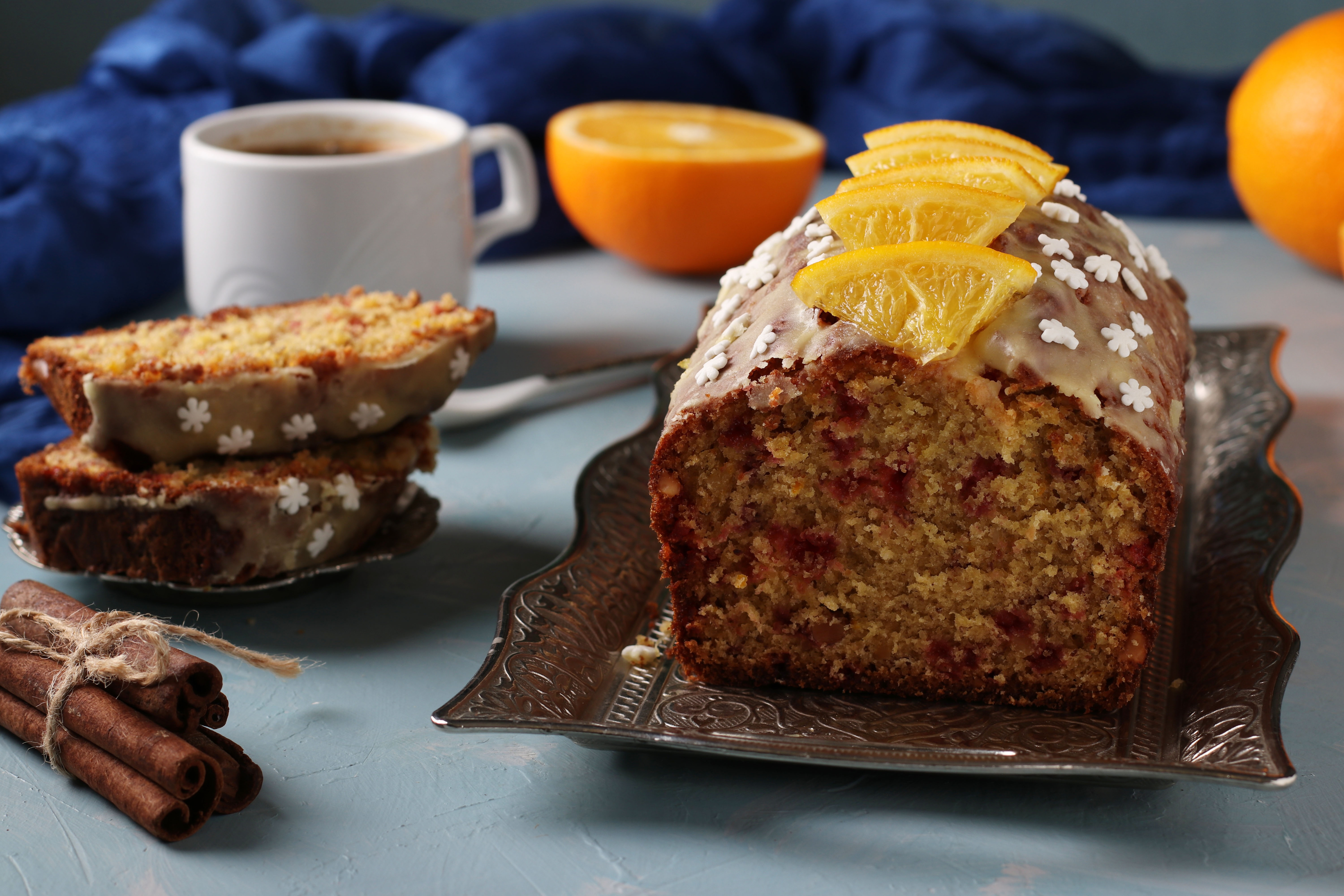 Cranberry orange cake sitting on a tray on the top of a table