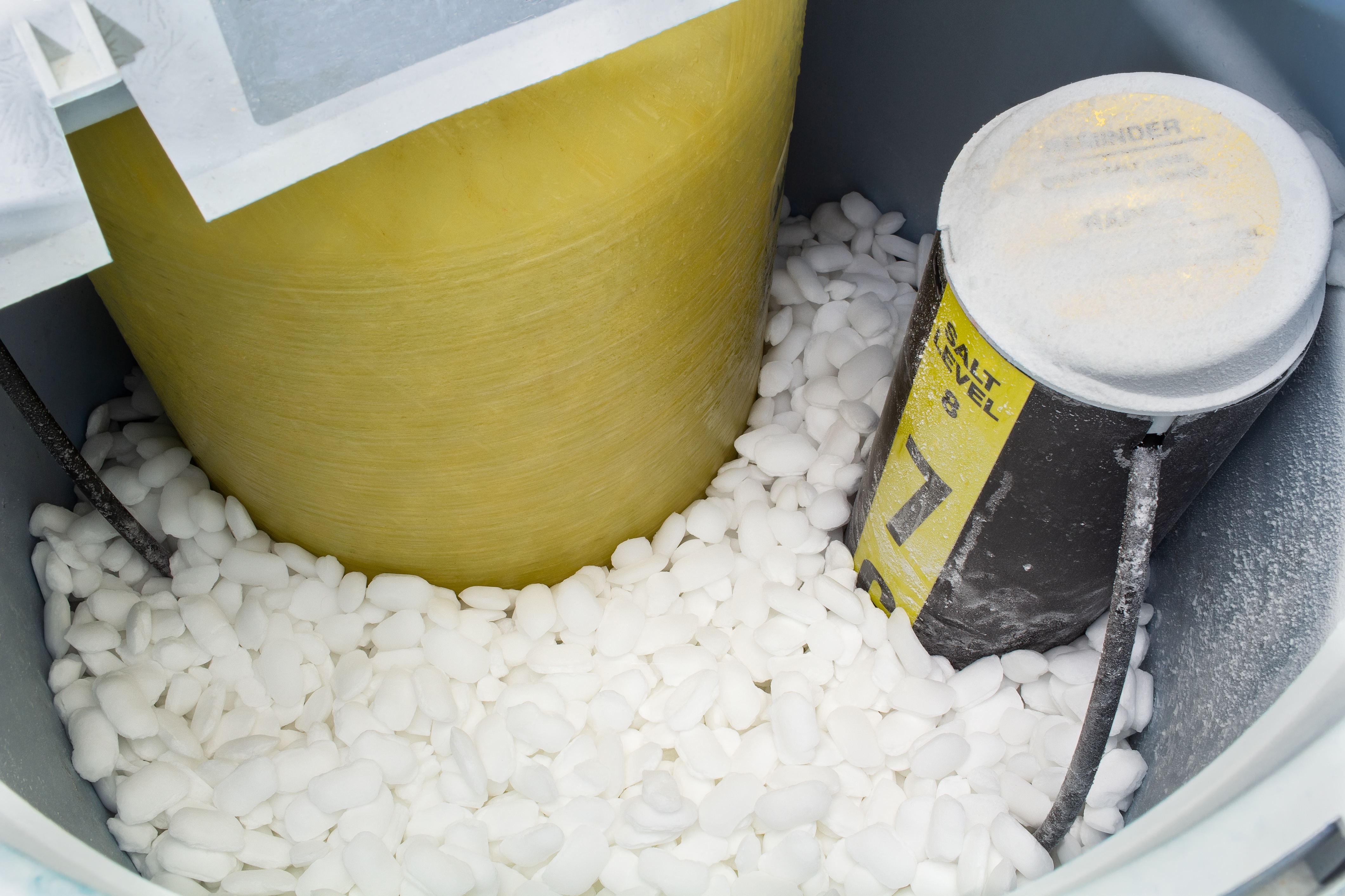 Water softener filled with salt crystals and tablets