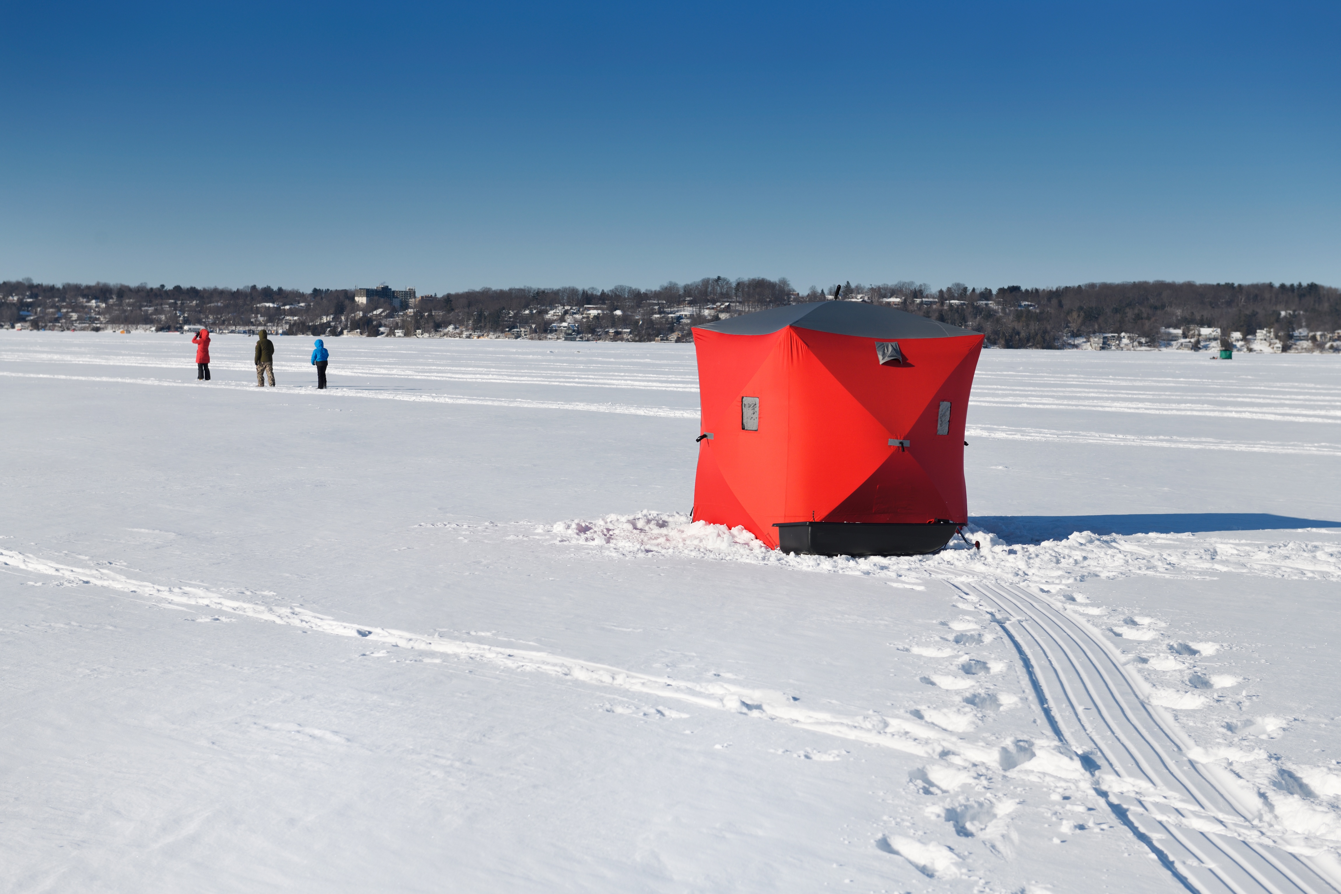 Red shelter on the ice on a cold snowy ice fishing day