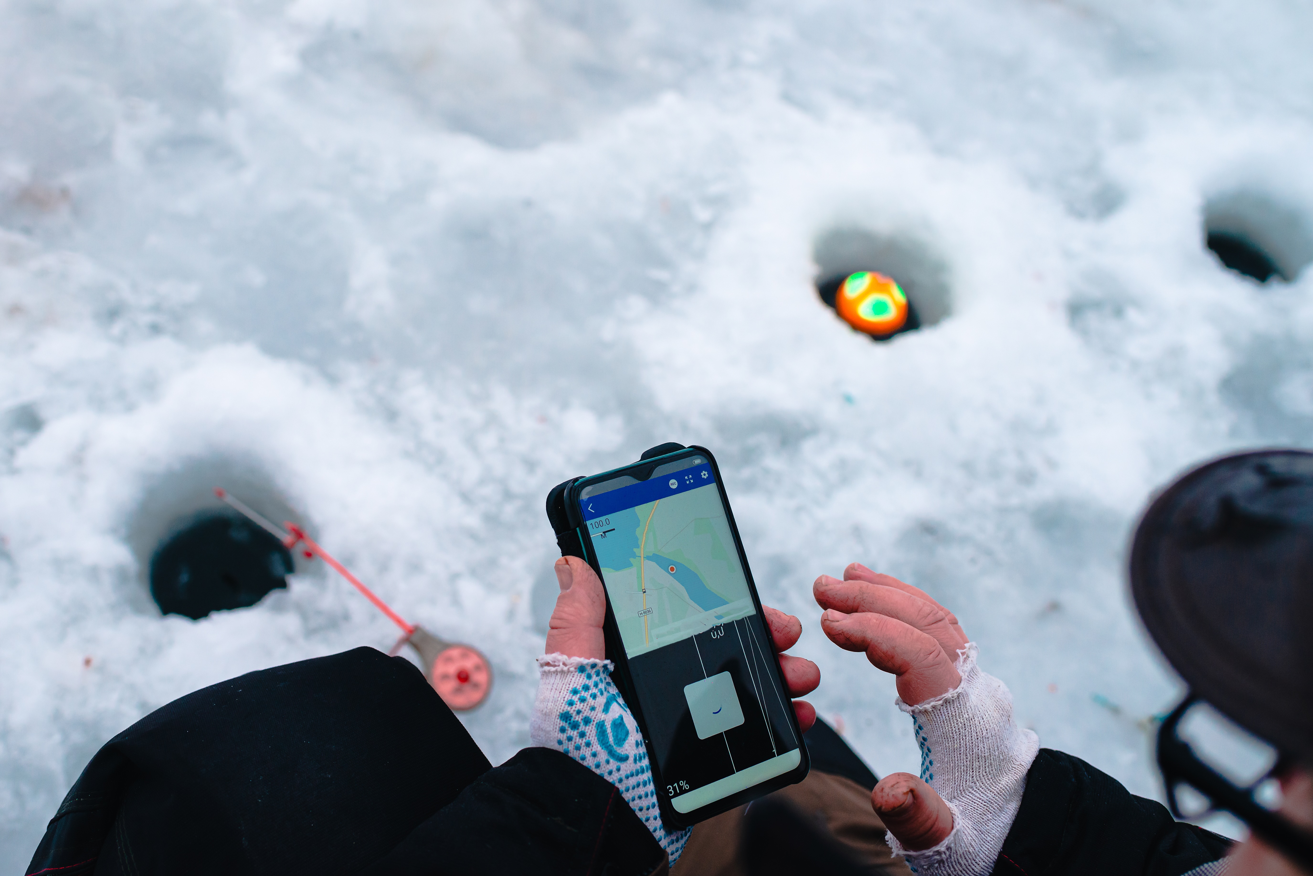 Person using technology to track fish while ice fishing