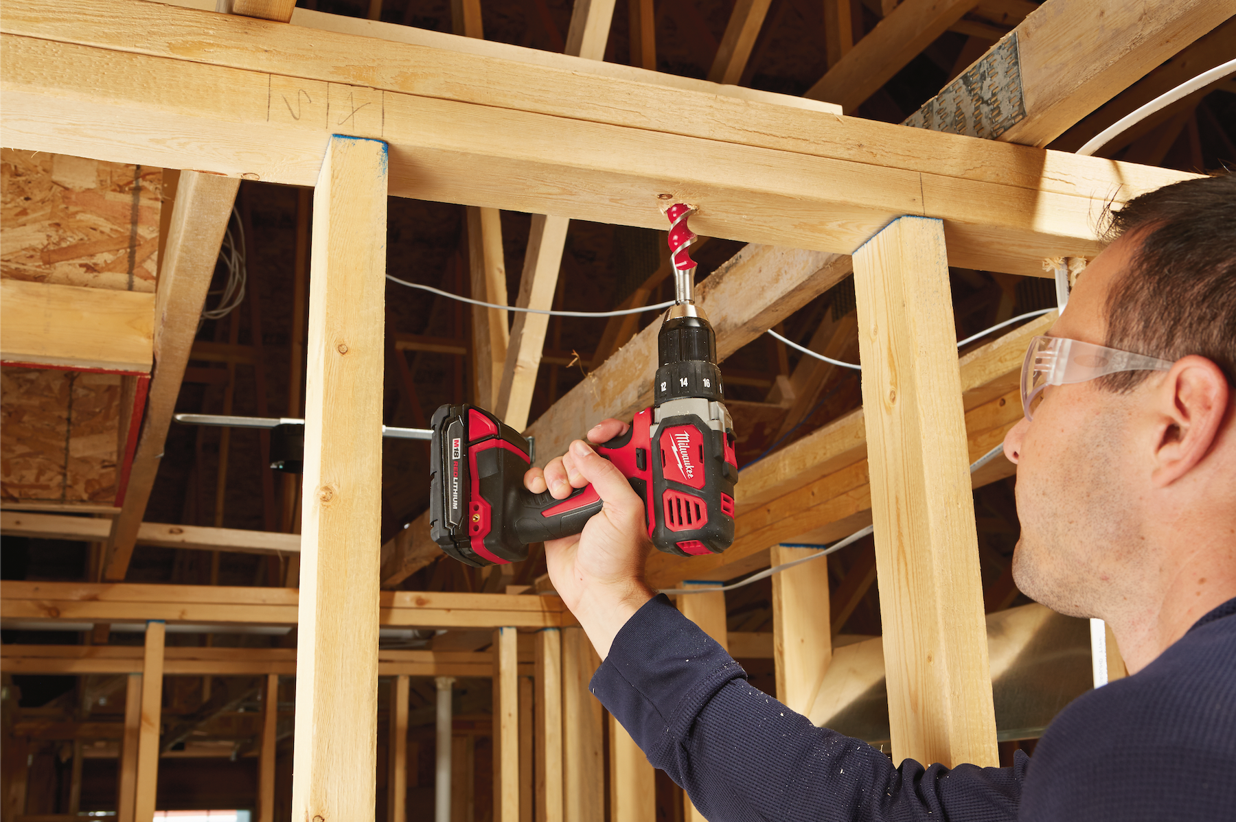Man using Milwaukee M18 Power Drill to drill into 2x4 wood