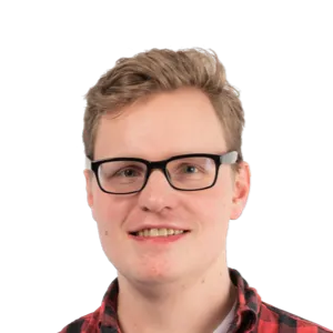 Young man with blonde hair wearing black-framed glasses and a red plaid shirt, smiling at the camera against a white background.