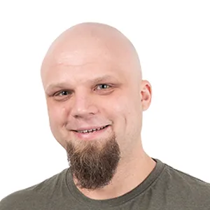 Bald man with goatee wearing olive green t-shirt, smiling at camera against white background