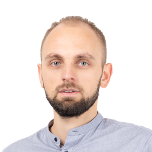 Professional headshot of a man with light brown hair and beard wearing a light blue shirt against a white background.