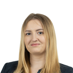 Professional headshot of a woman with long blonde hair wearing a dark blazer against a white background.