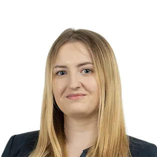 Professional headshot of a woman with long blonde hair wearing a dark blazer against a white background.
