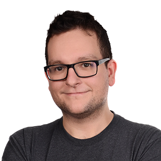 Headshot of a man wearing glasses and a dark gray t-shirt against a white background.