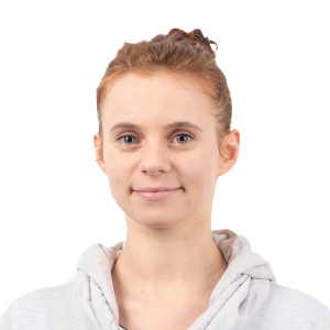 Portrait of a young girl with reddish-brown hair in a bun, wearing a light gray hoodie against a white background.
