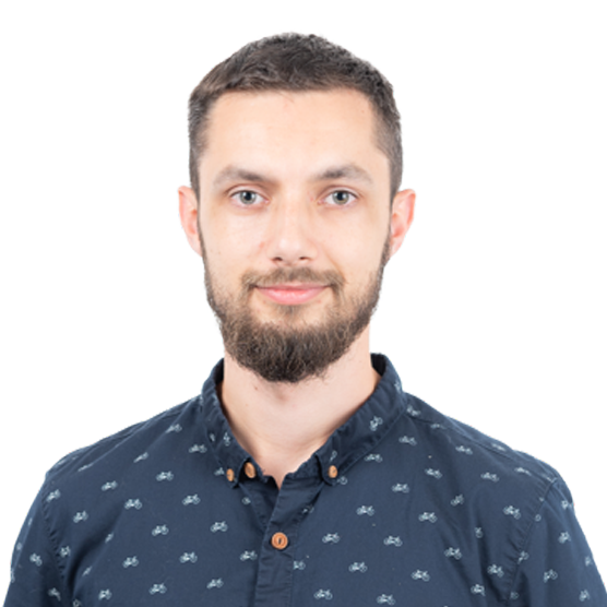Headshot of a man with a beard wearing a dark blue button-up shirt with a bicycle pattern against a white background.