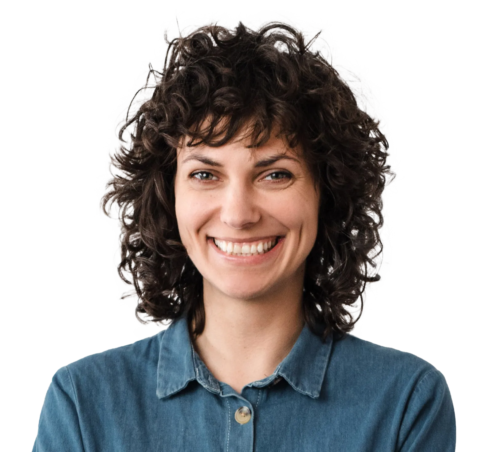 Smiling woman with dark curly hair wearing a blue denim shirt against a white background.
