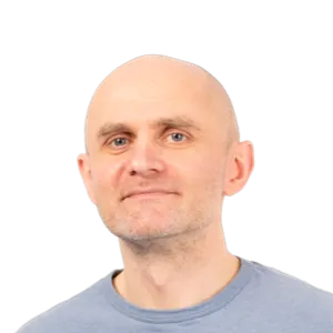 Headshot of a bald man with a neutral expression wearing a light blue t-shirt against a white background.