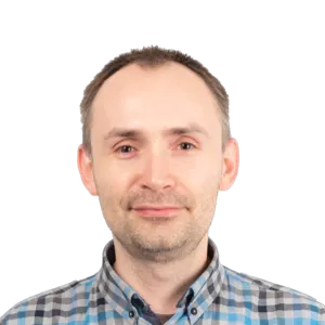 Headshot of a middle-aged man with short brown hair wearing a blue and white checkered shirt against a white background.