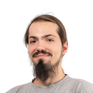Portrait of a man with long dark hair, mustache and goatee, wearing a gray t-shirt against a white background.