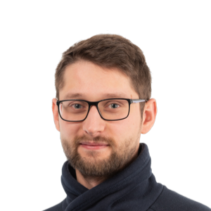 Headshot of a man with glasses and beard wearing a dark navy sweater against a white background.
