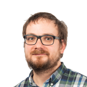 Headshot of a man with glasses and beard wearing a plaid shirt against a white background.