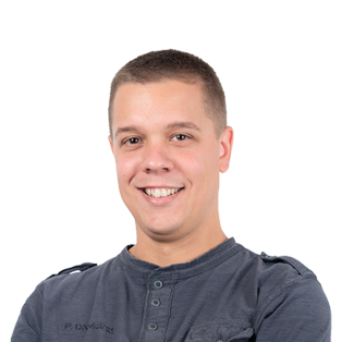 Headshot of a smiling young man with short brown hair wearing a dark blue henley shirt against a white background.