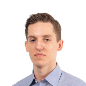 Headshot of a young man with brown hair wearing a light blue button-up shirt against a white background.