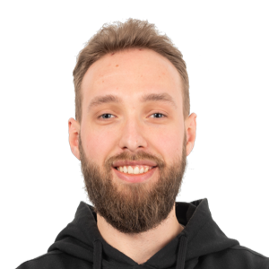 Headshot of a smiling man with a beard wearing a black hoodie against a white background.