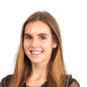 Professional headshot of a smiling woman with long reddish-brown hair wearing a dark colored top against a white background.