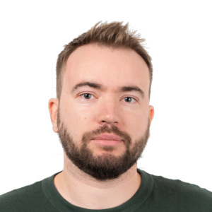 Headshot of a man with dark brown hair, beard, and light complexion wearing a dark green shirt against a white background.
