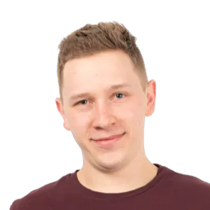 Portrait photograph of a young man with short brown hair wearing a dark maroon t-shirt against a white background.