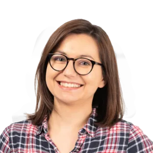 Woman wearing glasses and a plaid shirt smiling at the camera against a white background