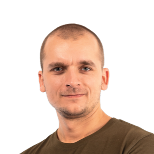 Headshot of a man with short blonde hair wearing a dark olive green t-shirt against a white background.