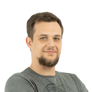 Portrait photo of a man with short brown hair and facial hair wearing a gray t-shirt against a white background.