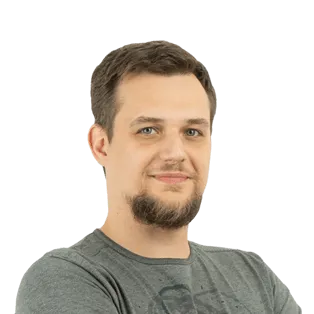 Portrait photo of a man with short brown hair and facial hair wearing a gray t-shirt against a white background.