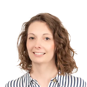 Headshot of a smiling woman with shoulder-length wavy brown hair wearing a striped shirt against a white background.