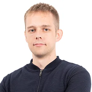 Headshot of a young man with short blonde hair wearing a dark blue striped zip-up jacket against a white background.