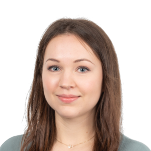 Headshot of a young woman with long brown hair wearing a gray-green top against a white background.