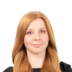 Portrait photograph of a woman with long reddish-auburn hair wearing a dark top against a white background.
