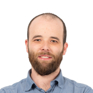 Headshot of a bearded man with light brown hair wearing a blue button-up shirt against a white background.