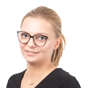Woman wearing cat-eye glasses and black top, smiling at camera against white background