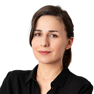 Professional headshot of a woman with long dark hair wearing a black collared shirt against a white background.