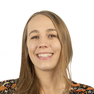 Smiling woman with long brown hair wearing a colorful patterned top against a white background
