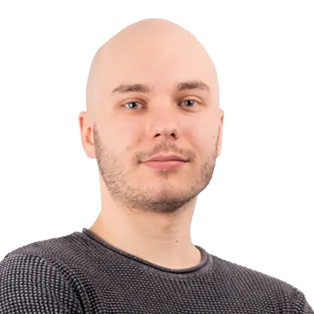 Headshot of a bald man with facial hair wearing a dark gray textured shirt against a white background.